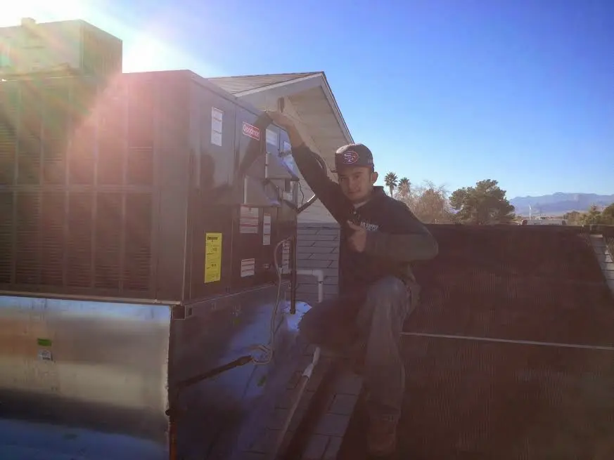 HVAC technician performing Air Duct Cleaning on a rooftop unit in Wilmington